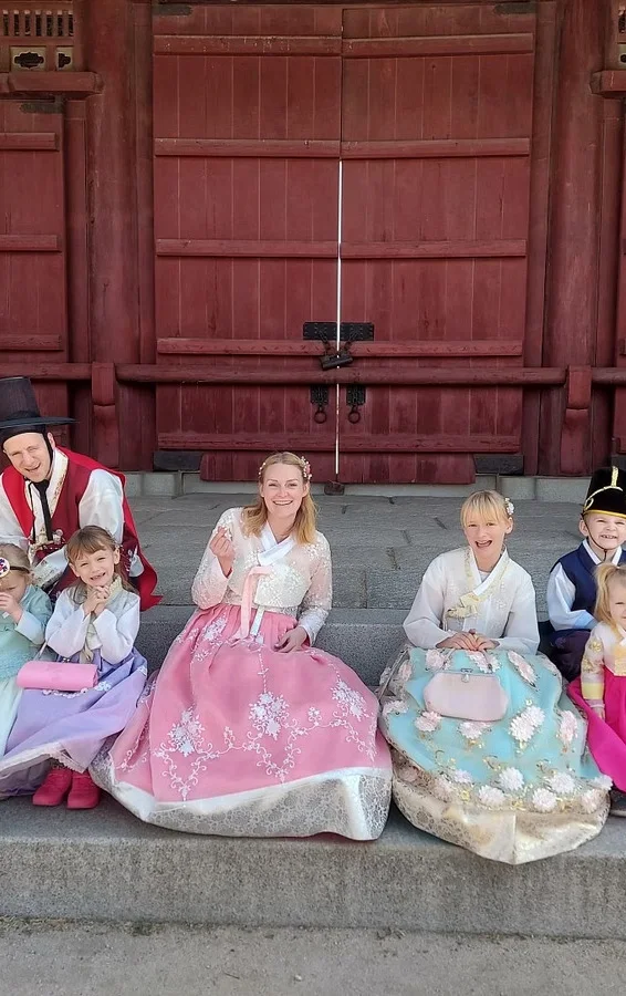 Familia vestida con hanbok de colores pastel en un palacio de Seúl