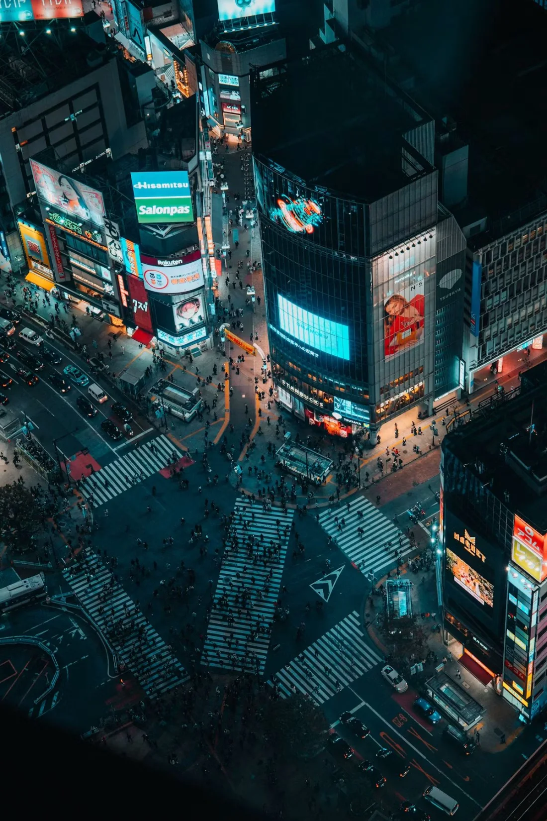 Vista aérea nocturna del cruce de Shibuya en Tokio, iluminado por anuncios de neón